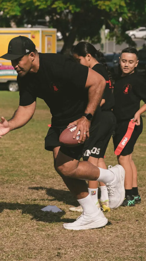 A coach carrying the ball with players in pursuit