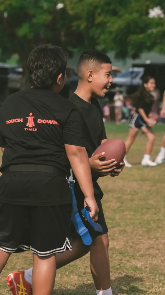 Two players laughing together, one holding the ball